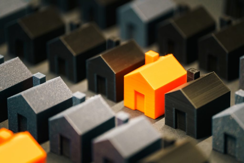 a-single-bright-house-stands-out-from-the-rest-sqmnlkuji-g houses miniature residential district highlight orange home 3d object background